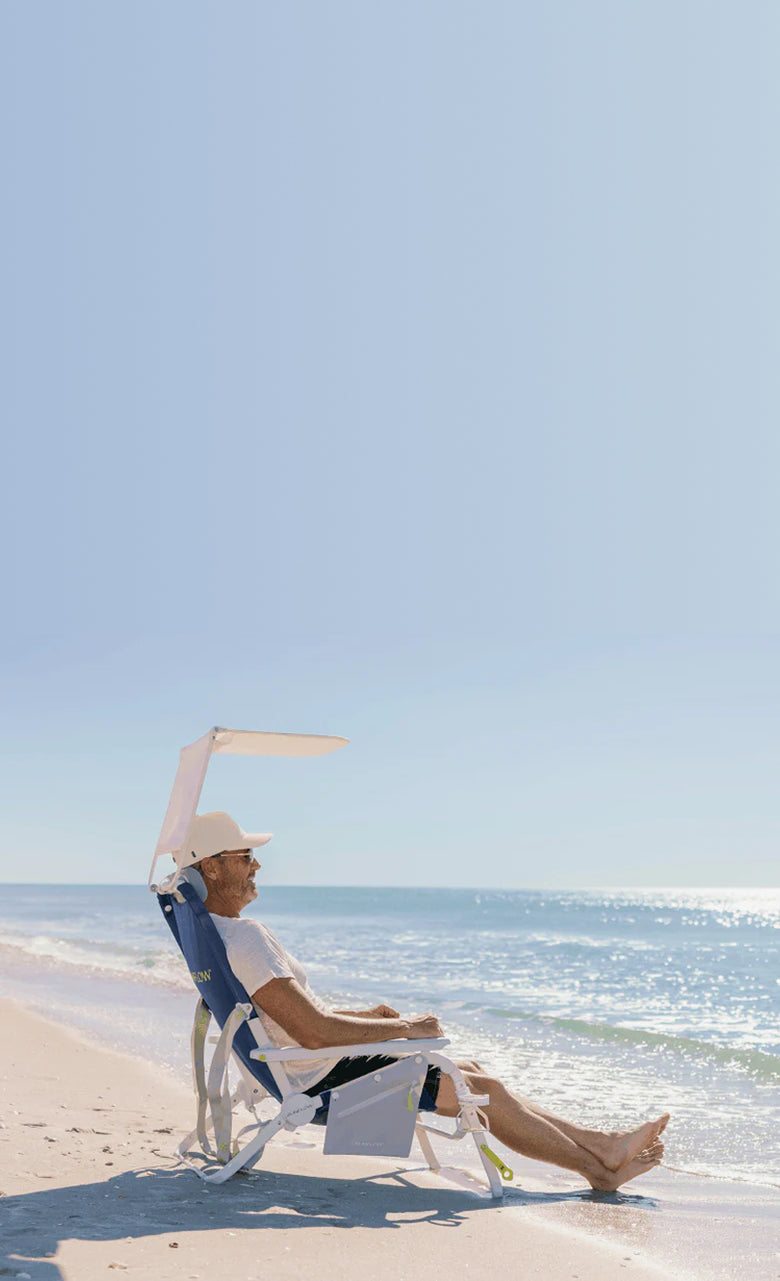 Man sitting in Sunflow chair non beach near waves